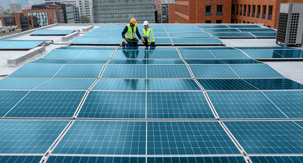 Team of engineers measguring solar panels on a rooftop using a tape measure